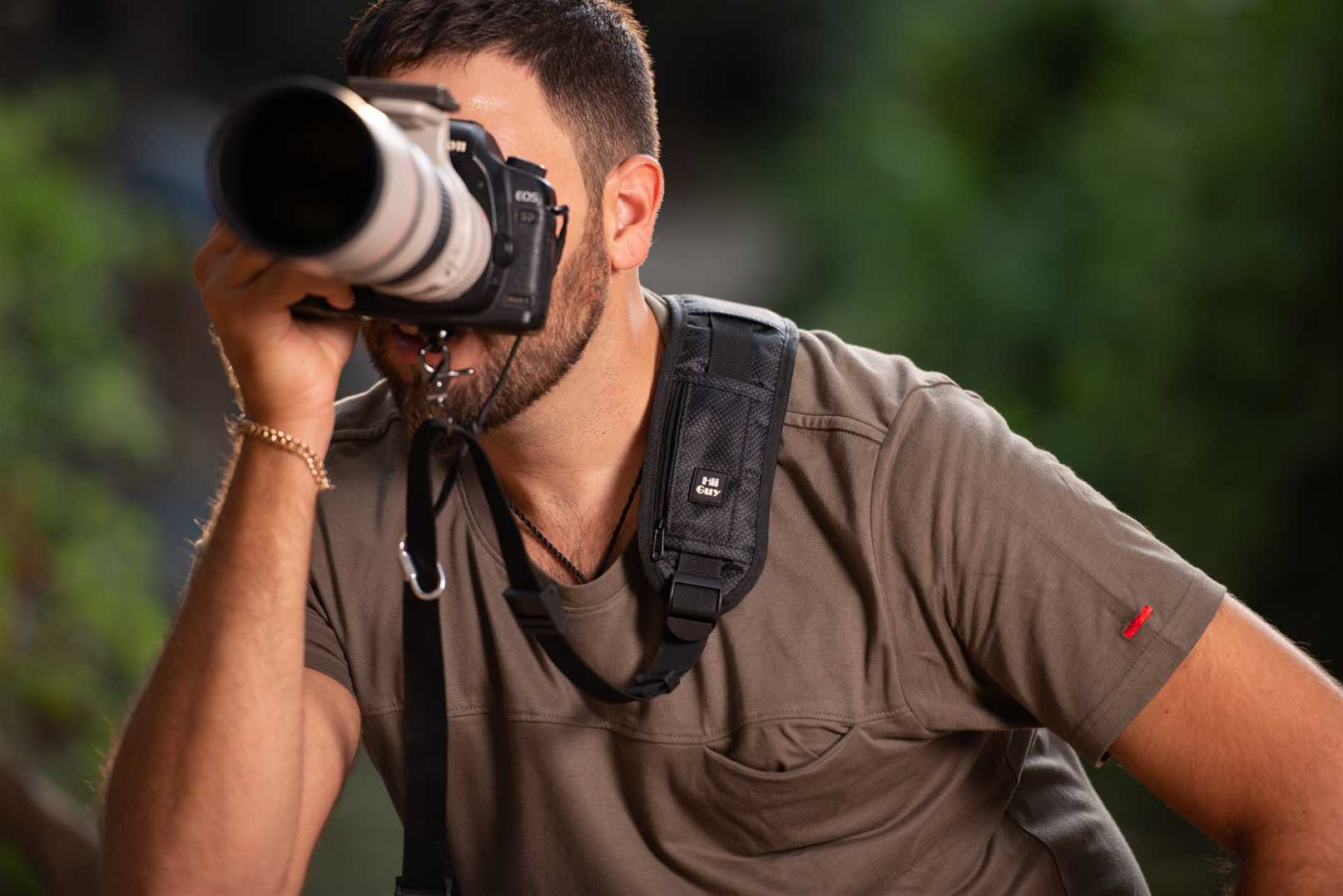 Photographer shooting with a DSLR carried on a HiiGuy shoulder strap