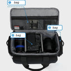 Black rectangular camera carrying bag with two top handles, a front zip pocket and a shoulder strap