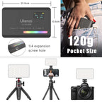 White pocket LED light with a small color screen, shown glowing in rainbow colors, with a diffuser cap, mount and cable