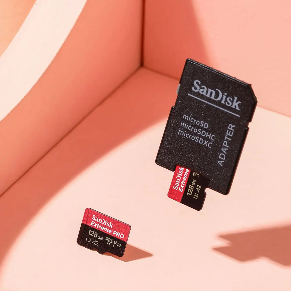Two SanDisk Extreme microSD cards, 256GB and 128GB, standing upright on a wooden surface