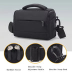 Black camera shoulder bag with a padded top handle, a zip front pocket and a clip-on shoulder strap