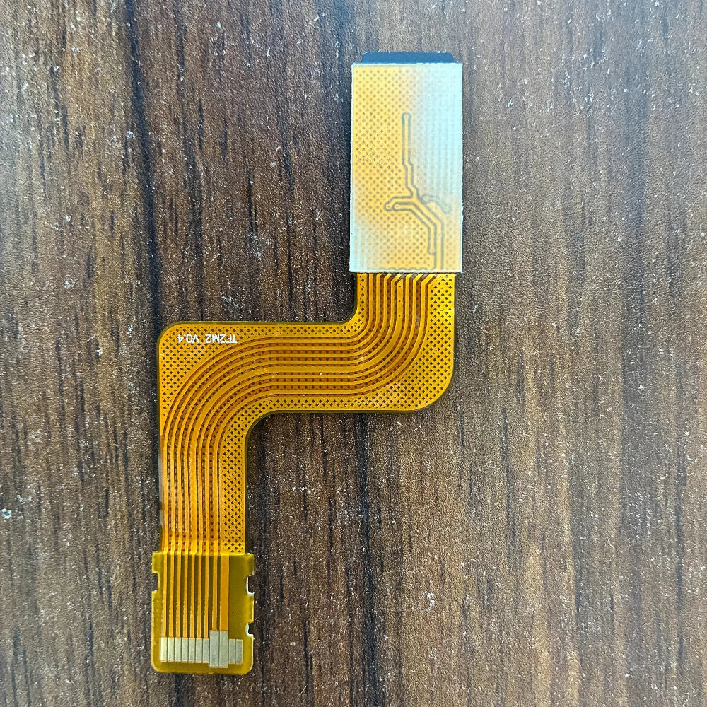 PSP Go console lying face up with an orange ribbon adapter attached at the left edge and a Memory Stick entry on screen