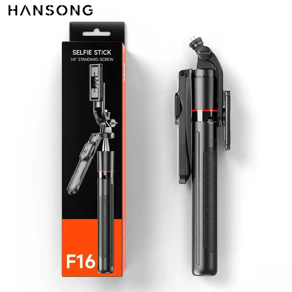 Black folded selfie stick with a red ring and a fold-out phone clamp, standing beside its black and orange F16 box