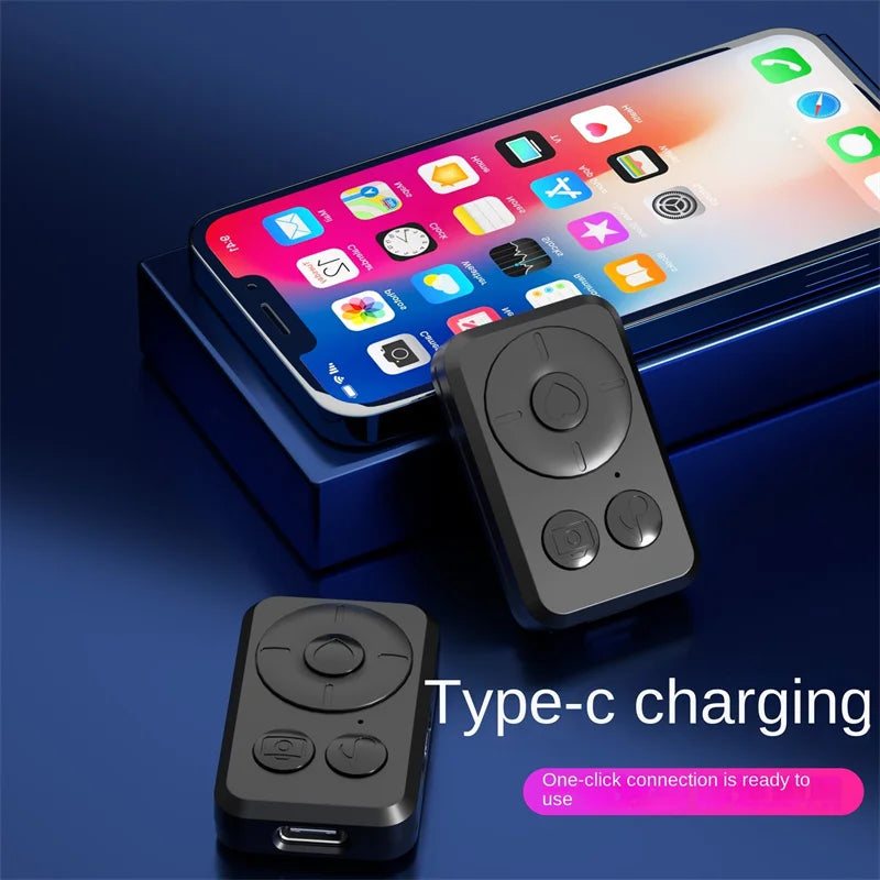 Black phone tripod extended on its legs with a smartphone on top and a remote on the pole, plus a folded one beside it