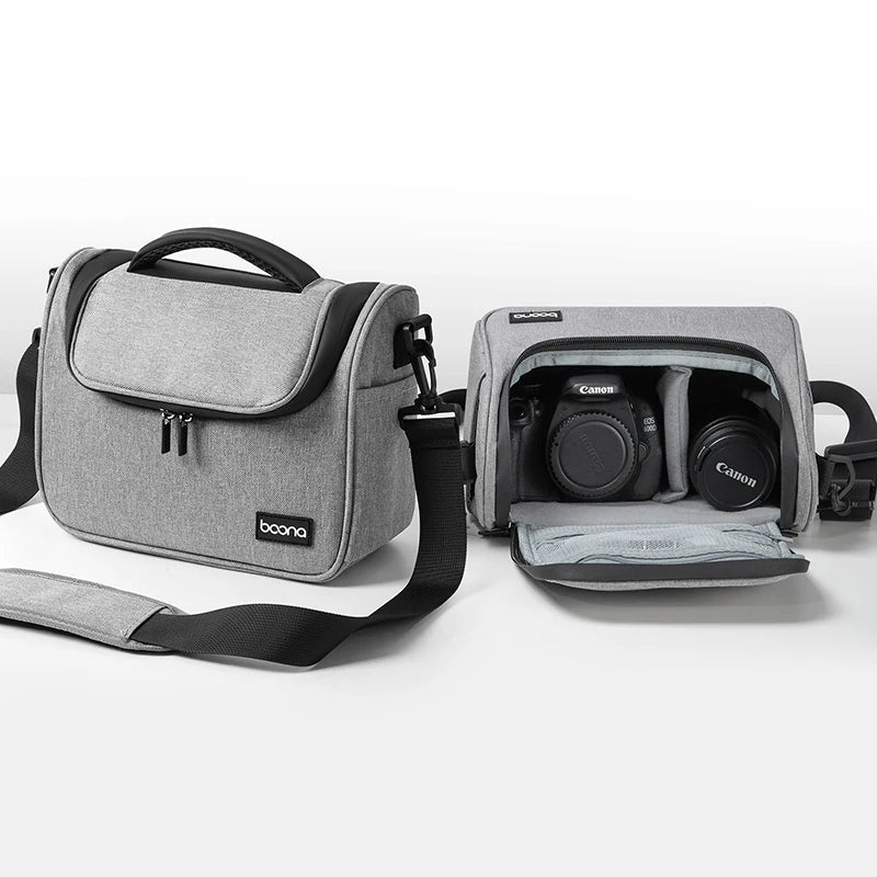 Grey camera shoulder bag with a black top handle and strap, beside an open one holding a DSLR and a lens