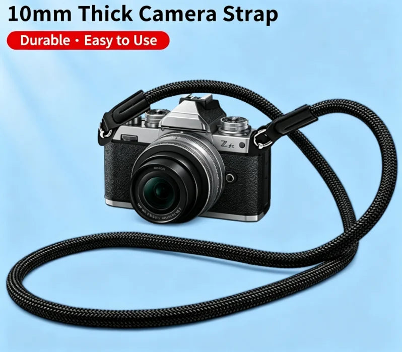 Black braided rope camera strap coiled on a dark surface, with a quick release clip and a cord loop at each end