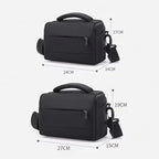 Black camera shoulder bag with a padded top handle, a zip front pocket and a clip-on shoulder strap