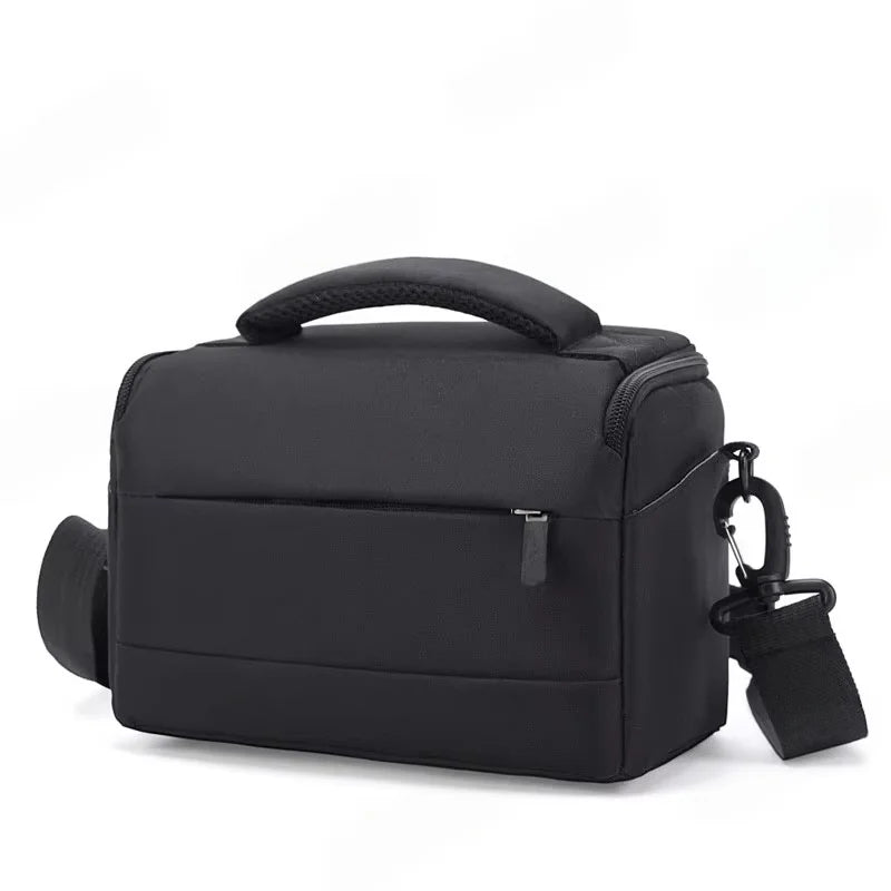 Black camera shoulder bag with a padded top handle, a zip front pocket and a clip-on shoulder strap