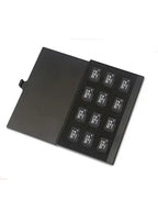 Open black metal card case holding twelve microSD cards in foam-lined slots