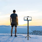 Black mini tripod handle with a rotating top and 1/4 inch screw, swinging a stick and holding a 360 camera on a table