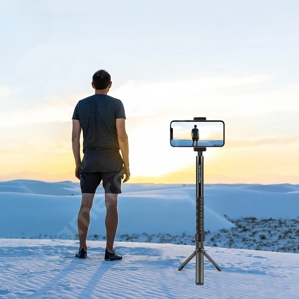 Black mini tripod handle with a rotating top and 1/4 inch screw, swinging a stick and holding a 360 camera on a table