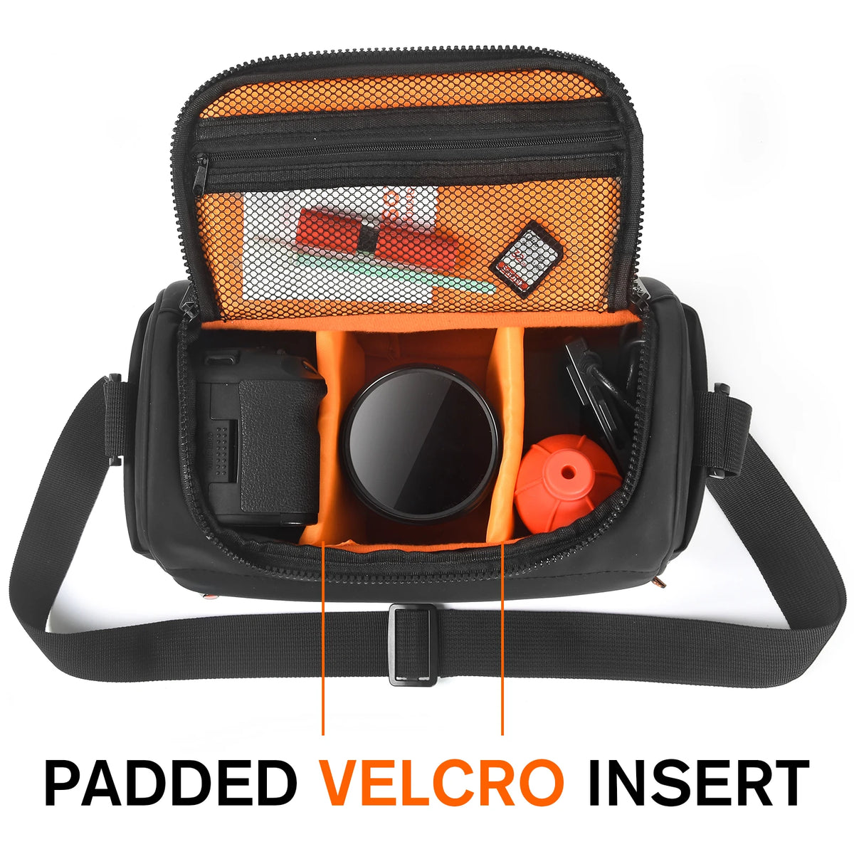 Black camera shoulder bag open to an orange padded interior, a small lens inside and a hand lowering a zoom lens in