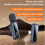 Black USB-C wireless receiver beside two clip-on transmitters with foam windscreens, digital displays and yellow buttons