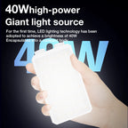 A white pocket-sized LED panel light glowing warm white, held in one hand against a dark background