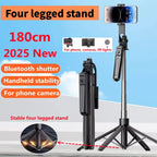 Black selfie stick tripod on a four-leg base holding a phone, with a detachable remote clipped to the pole