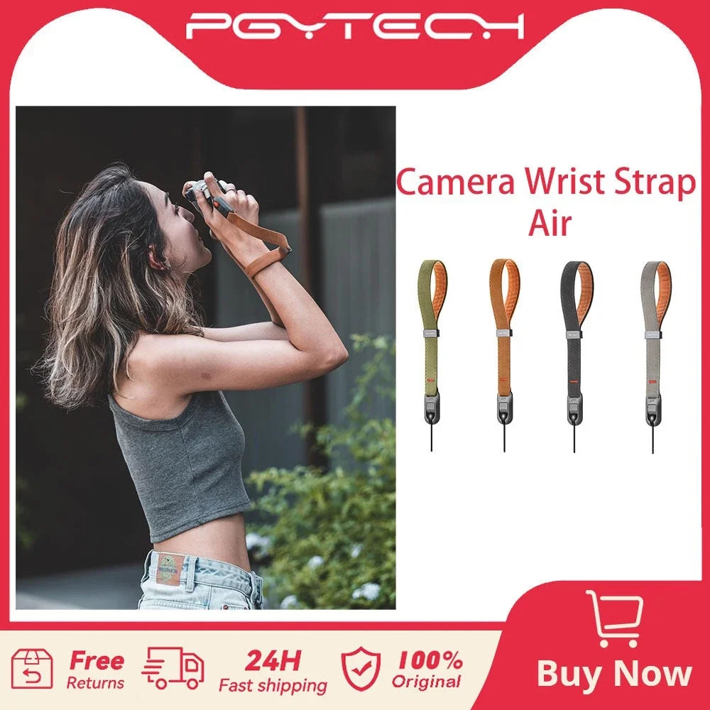 Woman shooting with a small camera on a brown wrist strap, beside the strap in green, tan, dark grey and light grey