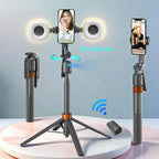 Black and orange selfie stick tripod holding a phone between two round fill lights, with a small remote and folded views