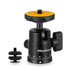 Black mini ball head with an orange rubber top plate, a locking knob and a degree scale, beside a double-nut shoe adapter