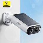 White Baseus Security bullet camera with a solar panel on top, mounted on a white wall against a blue sky