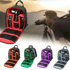 Small black camera backpack shown open with orange padded dividers holding a camera and lenses, with back and side views