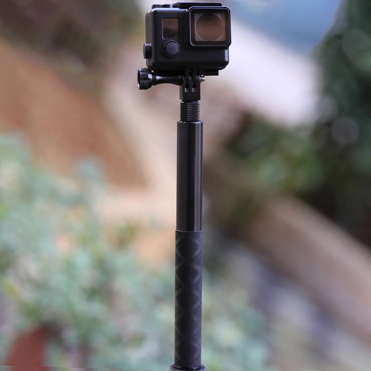 Two black carbon fiber selfie sticks, one long and one short, beside a folding bullet time handle